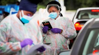 Medical technicians work at a drive-through coronavirus disease (COVID-19) testing facility at the Regeneron Pharmaceuticals company’s Westchester campus in Tarrytown, New York, September 17, 2020.