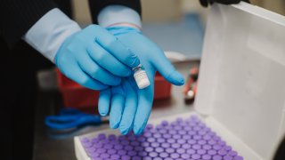 A pharmacy staff member unpacks a vial of the Pfizer-BioNTech Covid-19 vaccine at the University Of Louisville Hospital in Louisville, Kentucky, U.S., on Monday, Dec. 14, 2020.