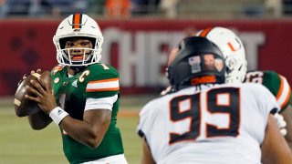 Miami quarterback D'Eriq King looks for a receiver as Oklahoma State defensive tackle Sione Asi rushes during the first half of the Cheez-it Bowl