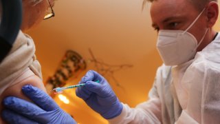 26 December 2020, Saxony-Anhalt, Halberstadt, Germany: Nurse Christopher Bock vaccinates a resident at an aged care facility in Halberstadt in Saxony Anhalt on Satuurday. Germany officially kicks off its coronavirus vaccination drive on Sunday.