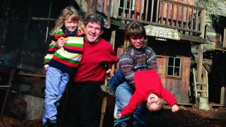 Matt Roloff (foreground, second from left) and wife Amy (foreground, second from right) with children Molly (foreground, left) and Jacob (foreground, right) playing on the playground Matt constructed complete w. Old West Town and a pirates ship.