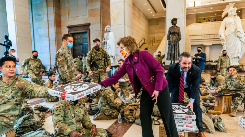 Rep. Vicky Hartzler, R-Mo., and Rep. Michael Waltz, R-Fla., hand pizzas to members of the National Guard gathered at the Capitol Visitor Center, Wednesday, Jan. 13, 2021, in Washington, D.C., as the House of Representatives continues with its fast-moving House vote to impeach President Donald Trump, a week after a mob of Trump supporters stormed the U.S. Capitol.