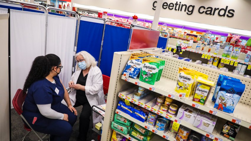 BOSTON – FEBRUARY 12: CVS Pharmacy Technician Leslie Carnejo, left, talks to RN Claire Karas after receiving the COVID-19 vaccine at a CVS in East Boston on Feb. 12, 2021. Some CVS locations began to offer COVID-19 vaccinations to eligible recipients beginning Feb. 12 at select locations in Rhode Island and Massachusetts through a new partnership with the federal government, the company confirmed Thursday. (Photo by Erin Clark/The Boston Globe via Getty Images)