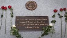 Roses are seen placed near a memorial plaque during a ceremony for all agents killed on duty thirty years after FBI agents Ben Grogan and Jerry Dove died in a gun battle with two heavily armed suspected bank robbers in Miami-Dade county on April 11, 2016 in Miramar, Florida. The shootout left five other agents wounded and the two serial bank robbers were killed by one of the wounded FBI agents.  (Photo by Joe Raedle/Getty Images)