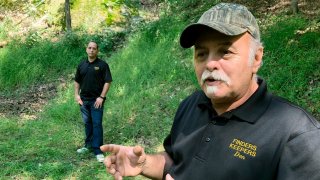 FILE-This Sept. 20, 2018 file photo, Dennis Parada, right, and his son Kem Parada stand at the site of the FBI's dig for Civil War-era gold in Dents Run, Pennsylvania. Government emails released under court order show that FBI agents were looking for gold when they excavated Dent's Run in 2018, though the FBI says that nothing was found.