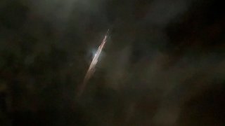 In this image taken from video provided by Roman Puzhlyakov, debris from a SpaceX rocket lights up the sky behind clouds over Vancouver, Wash. Thursday evening, March 25, 2021. The remnants of the second stage of the Falcon 9 rocket left comet-like trails as they burned up upon re-entry in the Earth's atmosphere according to a tweet from the National Weather Service.