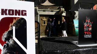 People enter the TCL Chinese Theater in Hollywood, California during its reopening on March 29, 2021. - The four directors of current and previous Godzilla and King Kong movies attended the reopening of the TCL Chinese Theater ahead of the new release of the latest Godzilla v Kong movie which will open on April 1st.