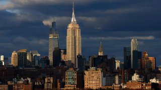 The sun sets on the skyline of midtown Manhattan, the Empire State Building, One Vanderbilt and the Chrysler Building in New York City