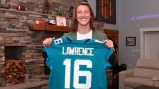 Clemson quarterback Trevor Lawrence holds up a jersey after being selected by the Jacksonville Jaguars with the first pick in the NFL football draft, Thursday, April 29, 2021, in Seneca, South Carolina.