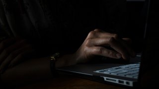 hand on laptop dark generic