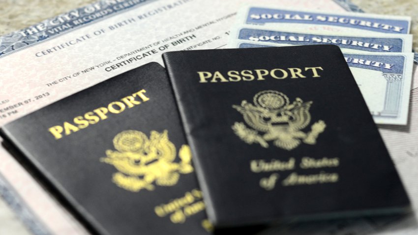 Diffterent forms of identification. pictured are three social security cards on  top of a birth certificate covered by two american passports.