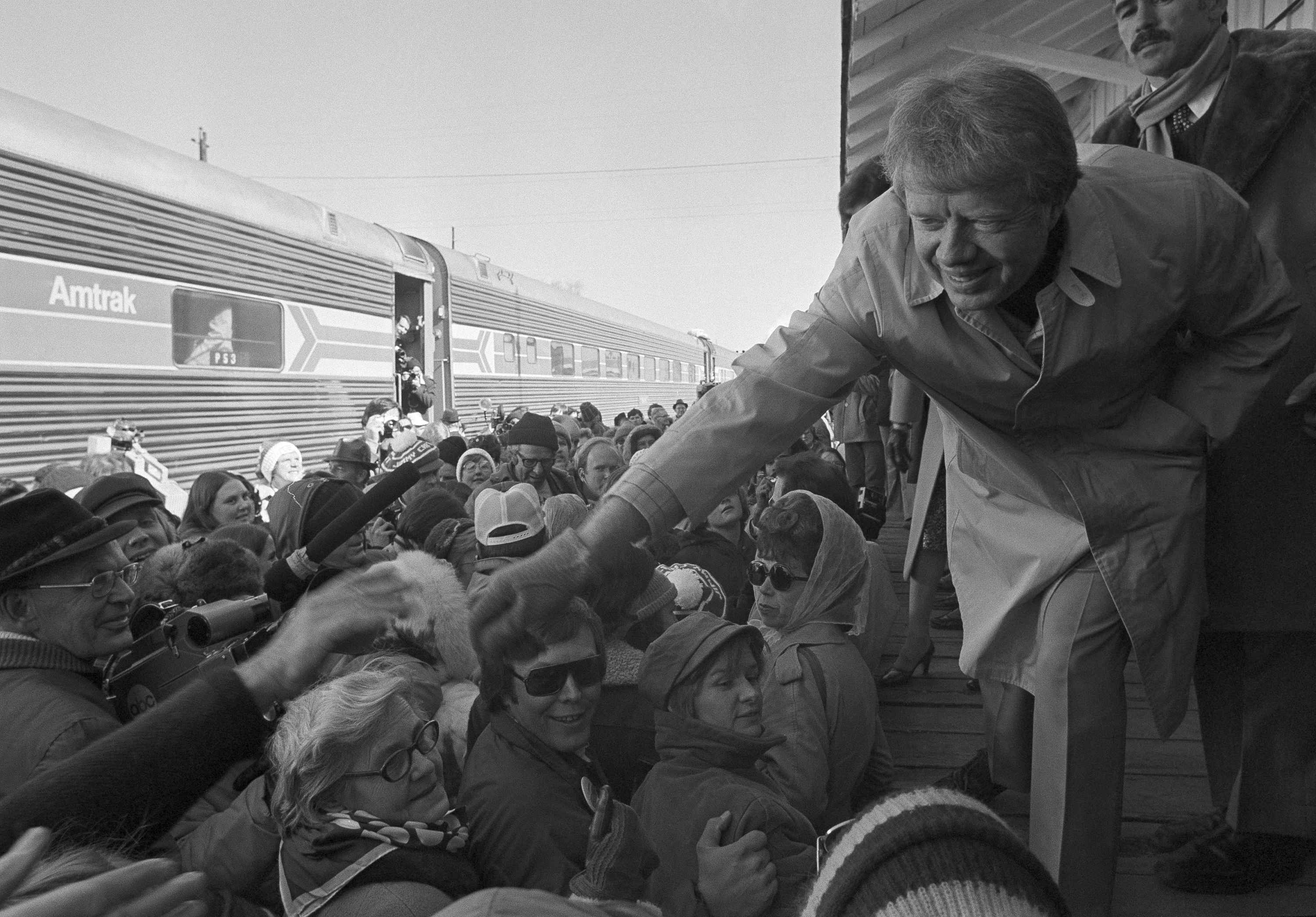 President-elect Jimmy Carter leans over to shake hands with some of the people riding the “Peanut Special” to Washington D.C., Jan. 19, 1977. They will travel all night, arriving in Washington in time for Carter’s inauguration as President the day after.