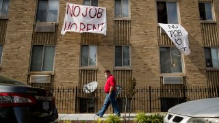 FILE - In this May 20, 2020, file photo, signs that read "No Job No Rent" hang from the windows of an apartment building during the coronavirus pandemic in Northwest Washington. The pandemic has shut housing courts and prompted authorities around the U.S. to initiate policies protecting renters from eviction. But not everyone is covered, and some landlords are turning to threats and harassment to force tenants out.