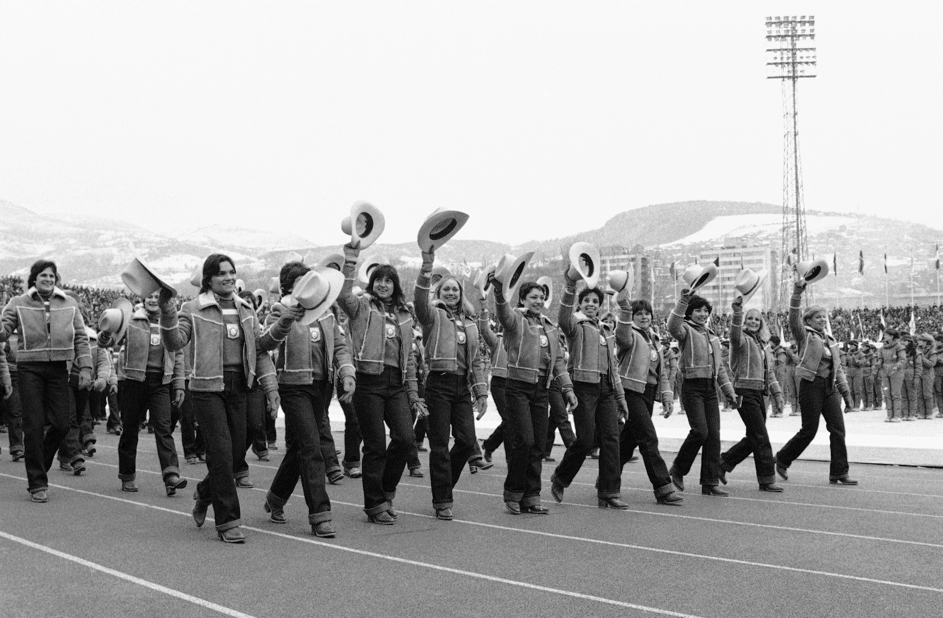 American Olympic athletes wave the cowboy hats that are part of their official Olympic uniforms on Feb. 8, 1984, as they march in Kosevo Stadium during opening ceremonies of the Winter Games in Sarajevo, Yugoslavia.