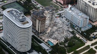 In this aerial view, search and rescue personnel work after the partial collapse of the 12-story Champlain Towers South condo building on June 24, 2021 in Surfside, Florida.