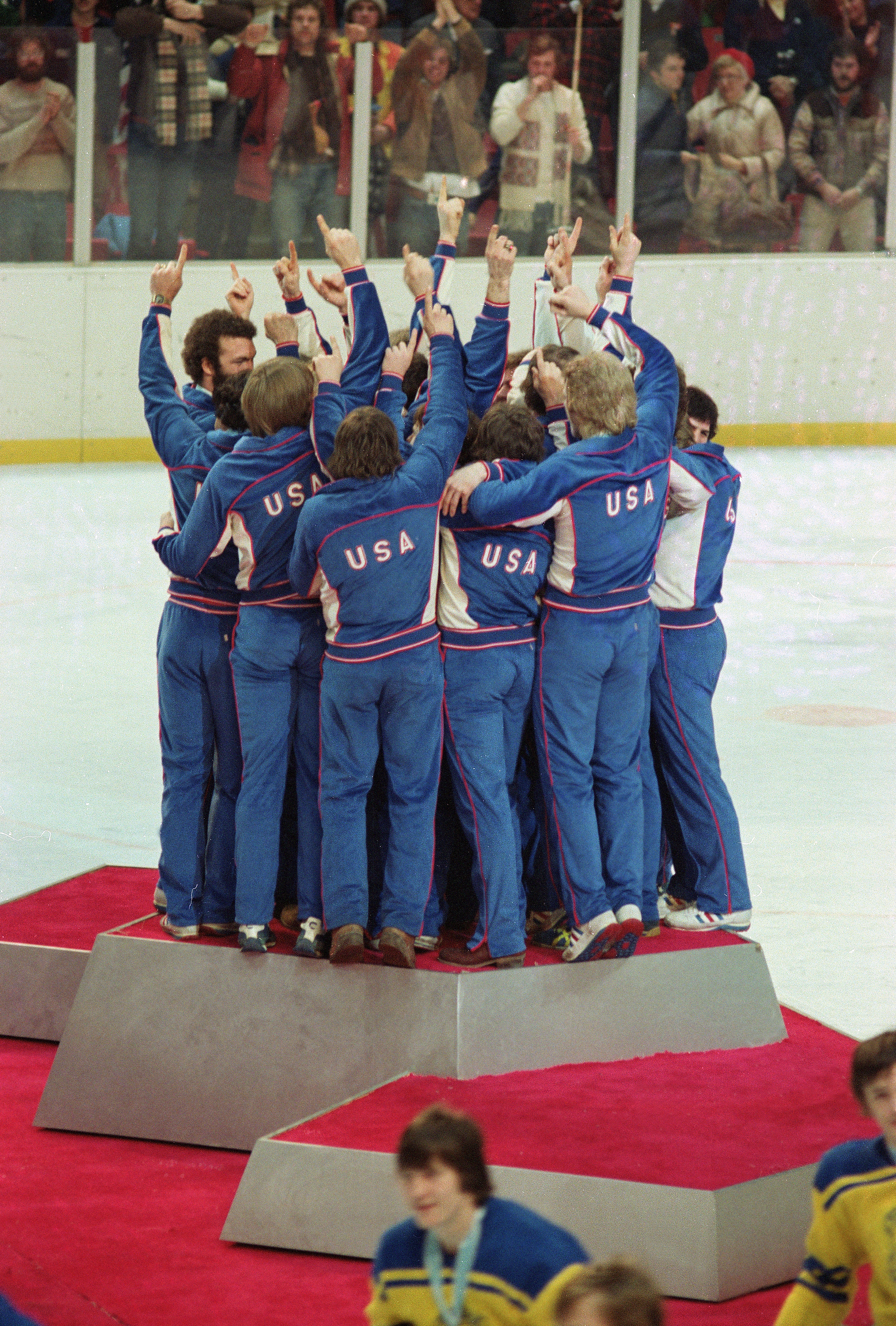 Members of the American Men’s Olympic ice hockey team celebrate on the medal podium after receiving their gold medals in Lake Placid, New York, on Feb. 24, 1980.