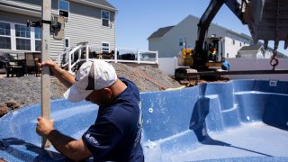 Ordini’s Best Fiberglass Pools contractors work to install a pool, which the company says have dramatically increased in sales due to COVID-19 fears, in Gilbertsville, Pennsylvania, April 26, 2021.
