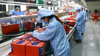 Employees assemble lithium-ion batteries at a factory on November 14, 2020 in Huaibei, Anhui Province of China.