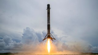 A Falcon 9 rocket booster lands after launching the company’s Transporter-2 rideshare mission on June 30, 2021.