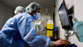 Member of the medical staff work in the hallways of the Intensive Care Unit where Covid-19 patients are hospitalised at the Etterbeek-Ixelles Hospital on April 6, 2021, in Brussels.