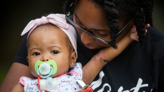 Tyesha Young, who lost her hospital job during the pandemic, holds her baby Jalayah Johnson
