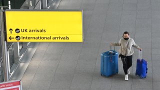A passenger with luggage is seen at London Heathrow Airport