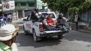 Two men, accused of being involved in the assassination of President Jovenel Moise, are being transported to the Petionville station in a police car in Port au Prince on July 8, 2021.