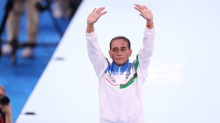 Eight-time Olympian Oksana Chusovitina waves after competing on vault at the Tokyo Olympics