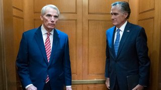 Sen. Rob Portman, R-Ohio, left, accompanied by Sen. Mitt Romney, R-Utah, leave in the elevator after closed door talks about infrastructure on Capitol Hill in Washington, July 15, 2021.