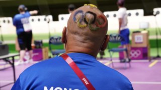 Mongolian shooting coach with hair cut into Olympic rings