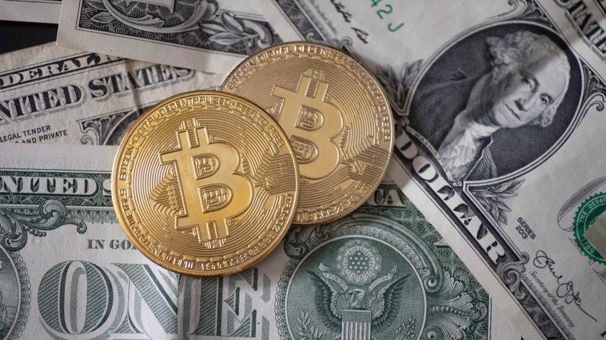 Bitcoin resting on on United States Dollar banknotes. Bitcoin with the symbol BTC, XBT is a popular digital currency that showed growth and is widely spread, accepted from banks, markets and other services and shops as ways of payments.