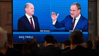 Journalists and party members watch on a screen from the press centre (L-R) Olaf Scholz, German Finance Minister, Vice-Chancellor and the Social Democrats (SPD) candidate for Chancellor and Armin Laschet, North Rhine-Westphalia’s State Premier and the Christian Democratic Union (CDU) candidate for Chancellor as they attend an election TV debate in Berlin on September 12.