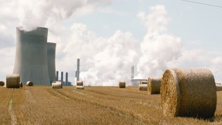 Round bales of straw drying on the field are seen in front of the power station operated by RWE AG near Rommerskirchen, Germany on August 10, 2021. The cost of natural gas and electricity has surged across Europe.