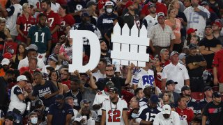A Tampa Bay Buccaneers fan holds a sign during the first half of an NFL football game against the Dallas Cowboys