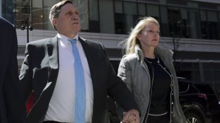 In this April 3, 2019 file photo, investor John Wilson, left, arrives at federal court in Boston with his wife Leslie to face charges in a nationwide college admissions bribery scandal.