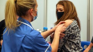 Caroline Nicolls receives an injection of the Moderna Covid-19 vaccine administered by nurse Amy Nash at the Madejski Stadium in Reading, England, on April 13, 2021.