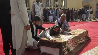 Relatives and residents attend a funeral ceremony for victims of a suicide attack