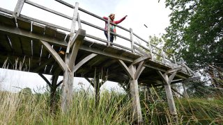 Silke Lohmann of Summers Place Auctions stands on the original Poohsticks Bridge from Ashdown Forest