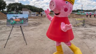 Peppa Pig makes an appearance during a media tour of the Peppa Pig Theme Park construction progress