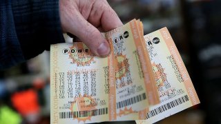 A customer holds a handful of Powerball tickets