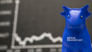 A toy bull sits in front of the DAX Index curve at the Frankfurt Stock Exchange in Germany.