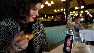 Erin Tridle holds a video chat with her boyfriend Jordan Commarrieu living in Paris from their favorite French restaurant "Petit Trois" in Los Angeles on Nov. 5, 2021.