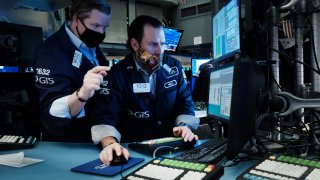 A trader works on the floor of the New York Stock Exchange (NYSE) at the start of trading on Monday following Friday’s steep decline in global stocks over fears of the new omicron Covid variant on December 20, 2021 in New York City.