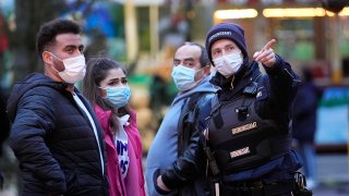 A public order officer gives indications at the Christmas market in Dortmund, Germany, Wednesday, Dec. 1, 2021. Germany tightened the COVID-19 rules, while many Christmas markets were closed, the market in Dortmund now allows only vaccinated or recovered people due to the coronavirus pandemic.