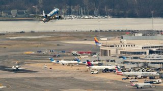 An Alaska Airlines plane takes off from Ronald Reagan National Airport in Arlington, Virginia, on January 18, 2022, as seen from Washington, DC.