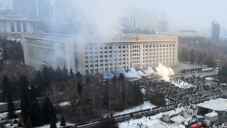 Smoke rises from the city hall building during a protest in Almaty, Kazakhstan, Wednesday, Jan. 5, 2022. News outlets in Kazakhstan are reporting that demonstrators protesting rising fuel prices broke into the mayor's office in the country's largest city and flames were seen coming from inside. Kazakh news site Zakon said many of the demonstrators who converged on the building in Almaty on Wednesday carried clubs and shields.