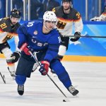 Team USA's Matty Beniers carries the puck during the men's preliminary round at the 2022 Winter Olympic Games ice hockey competition between USA and Germany, Feb. 13, 2022.
