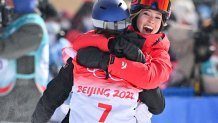 China's Eileen Gu (R) hugs winner Switzerland's Mathilde Gremaud after the Freestyle Skiing Women's Freeski Slopestyle final run during the 2022 Winter Olympics at the Genting Snow Park H & S Stadium in Zhangjiakou, China on Feb. 15, 2022.