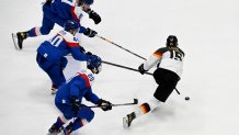 Slovakia's Pavol Regenda, Slovakia's Milos Roman, Slovakia's Juraj Slafkovsky and Germany's Stefan Loibl (L to R) vie during the men's qualification play-off match of the 2022 Winter Olympics ice hockey competition between Slovakia and Germany, at the National Indoor Stadium in Beijing, China on Feb. 15, 2022.