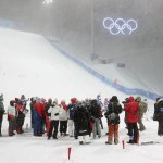 Officials and team staff gather as the Women's Freestyle Skiing Aerials qualifications are postponed due to weather at Genting Snow Park for the 2022 Winter Olympics, Feb. 13, 2022, in Zhangjiakou, China.